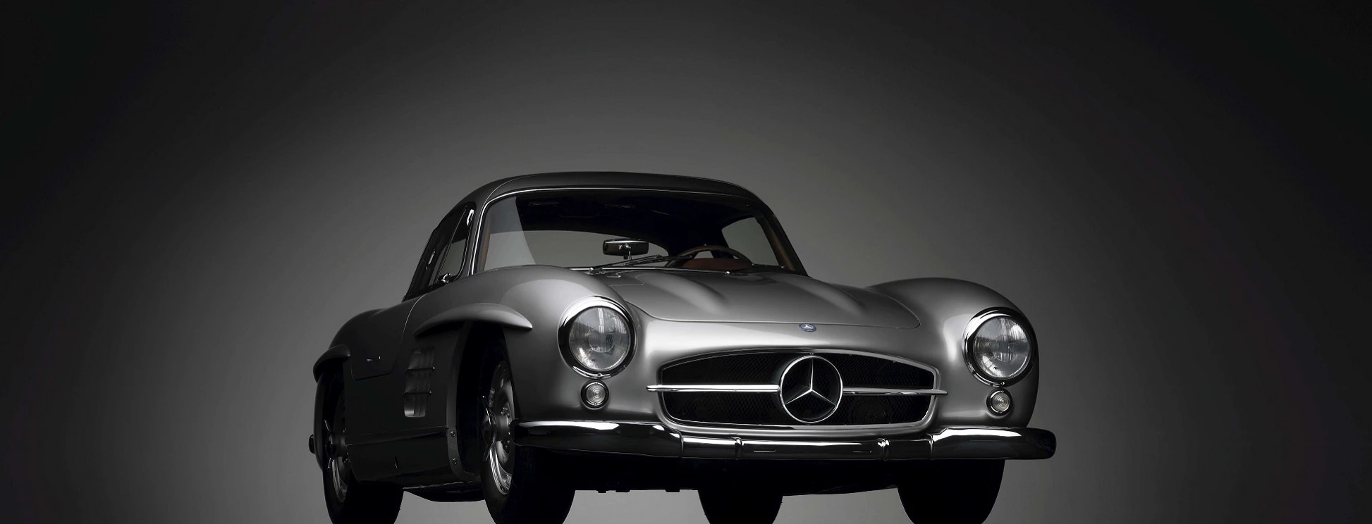 Silver Mercedes-Benz 300 SL Gullwing coupé photographed from the front in a studio