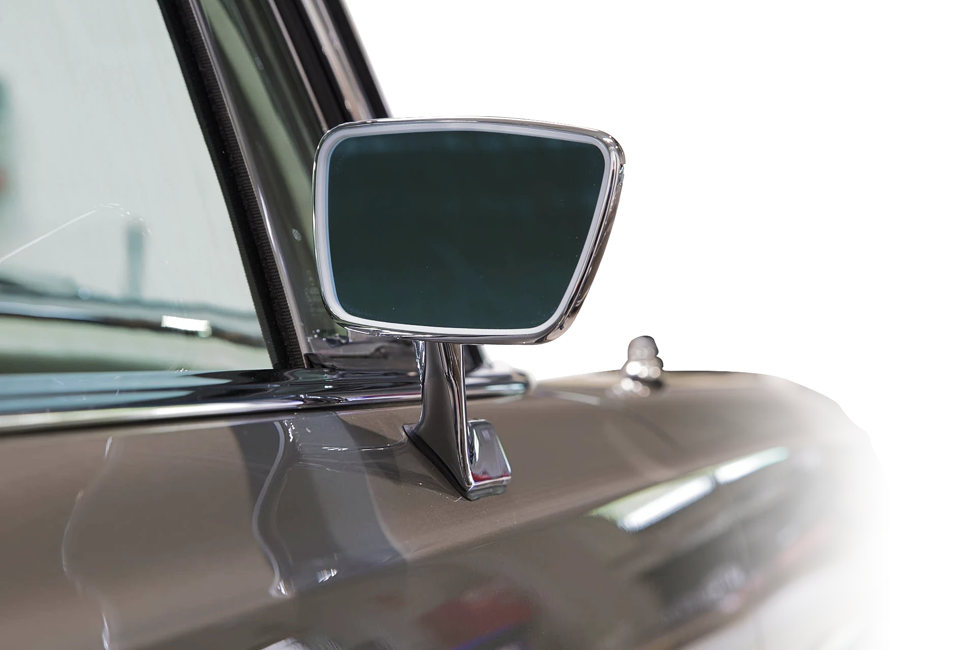 Close-up of the chrome wing mirror of a restored classic Mercedes-Benz in the workshop