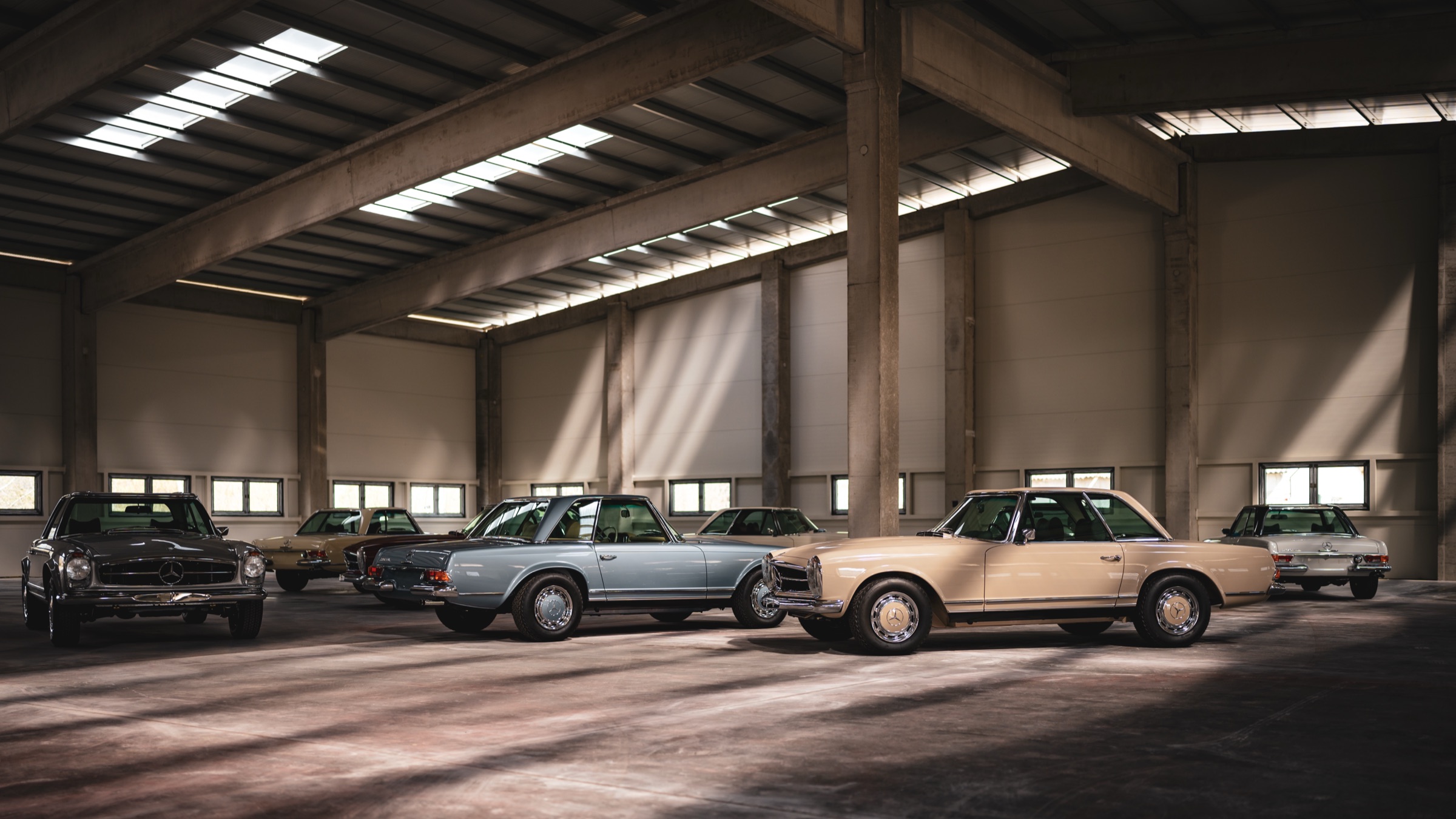 Wide view of the Motor Classic hall with several Pagodas parked under the skylights