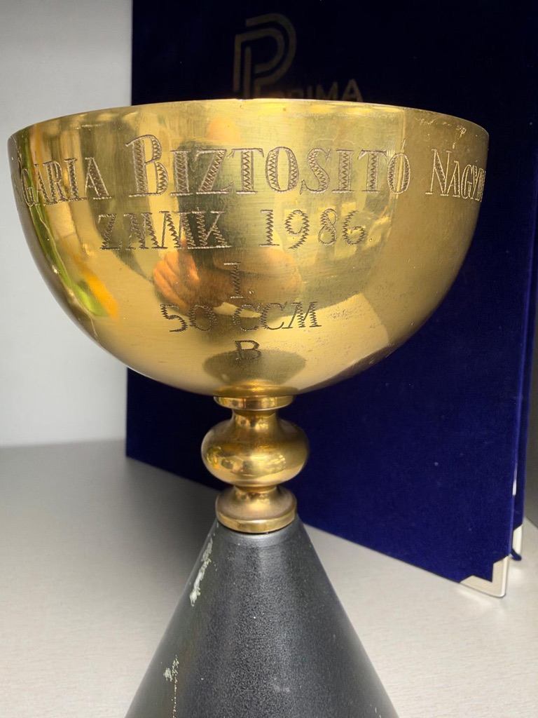 A gold cup engraved with the 1986 Hungária insurance grand prix, 50 cc class B, first place
